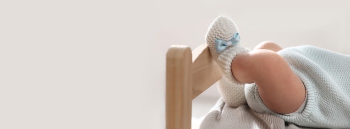 Image of Adorable newborn baby on small wooden bed indoors, closeup view with space for text. Banner design