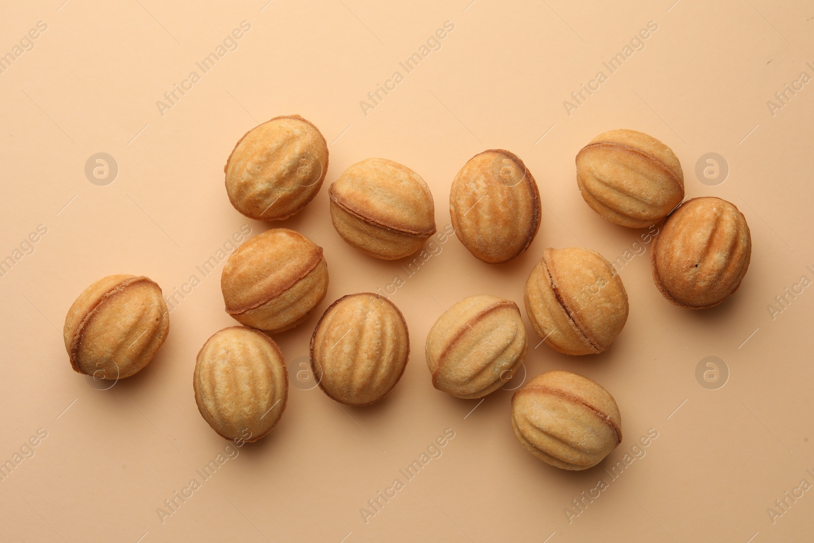 Homemade walnut shaped cookies with condensed milk on beige background, flat lay Photo of Homemade walnut shaped cookies with condensed milk on beige background, flat lay