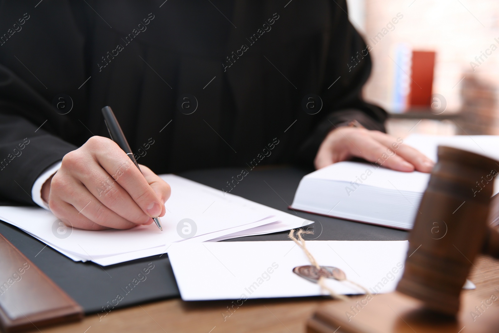 Photo of Judge working with papers at table in office, closeup. Law and justice concept