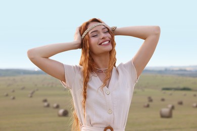 Photo of Portrait of beautiful happy hippie woman in field