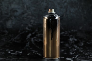 Photo of Used can of spray paint on black marble background. Space for text