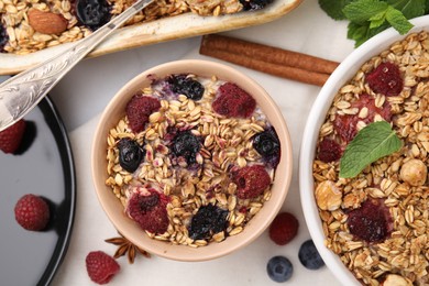 Tasty baked oatmeal with berries on white table, flat lay