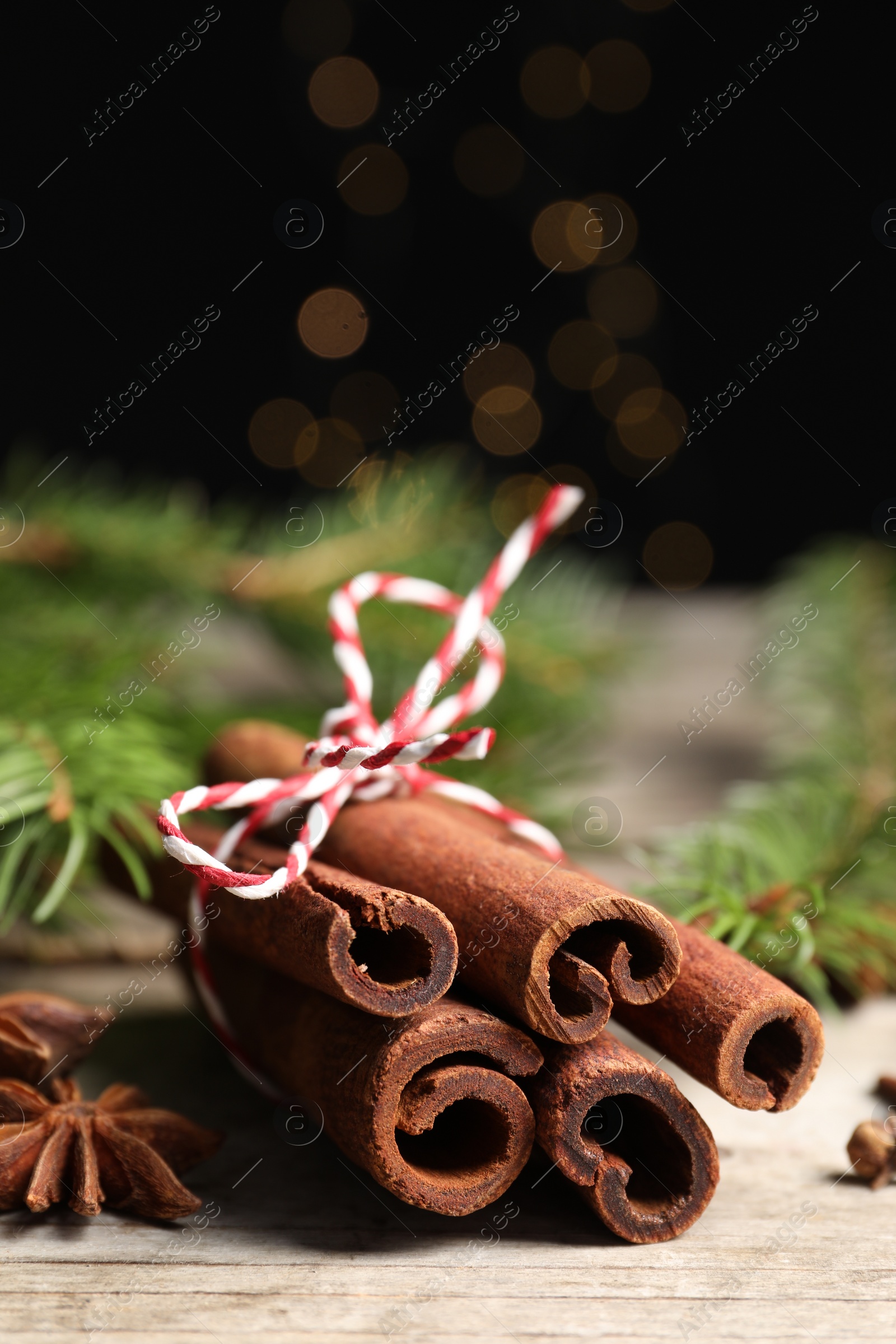 Photo of Different spices and fir branches on wooden table, closeup