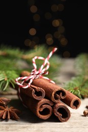 Different spices and fir branches on wooden table, closeup