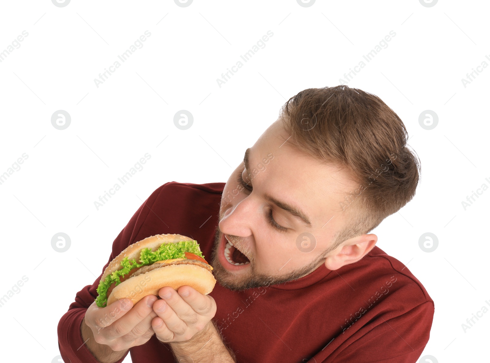 Photo of Young man eating tasty burger on white background