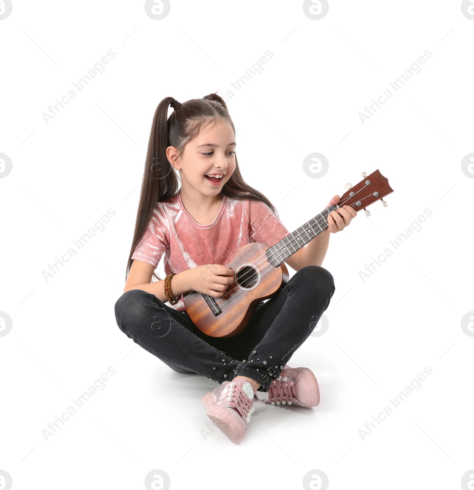 Photo of Little cheerful girl playing guitar, isolated on white