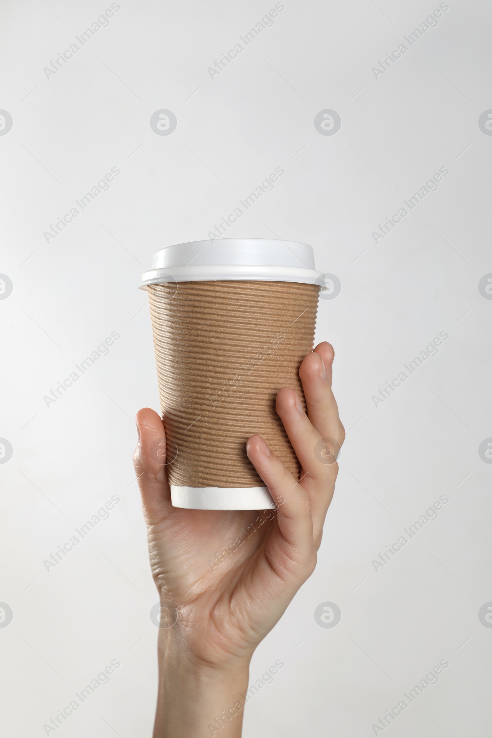 Photo of Woman holding takeaway paper coffee cup on white background, closeup