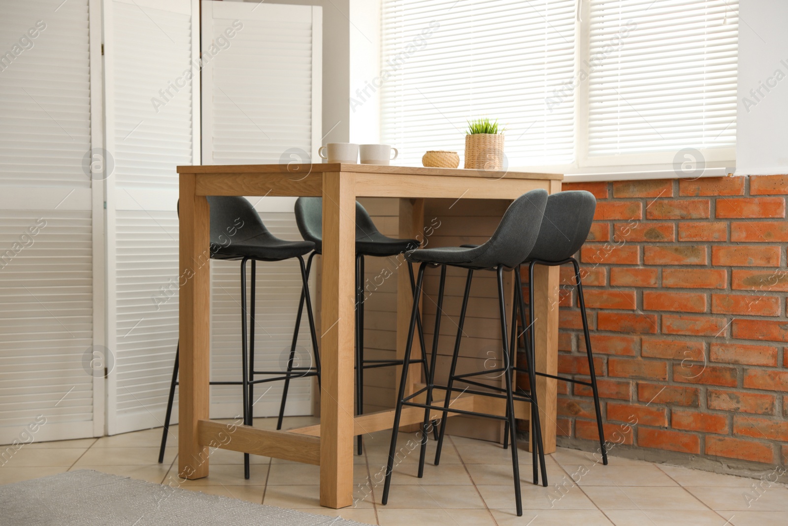 Photo of Stylish dining room interior with modern table set and window blinds