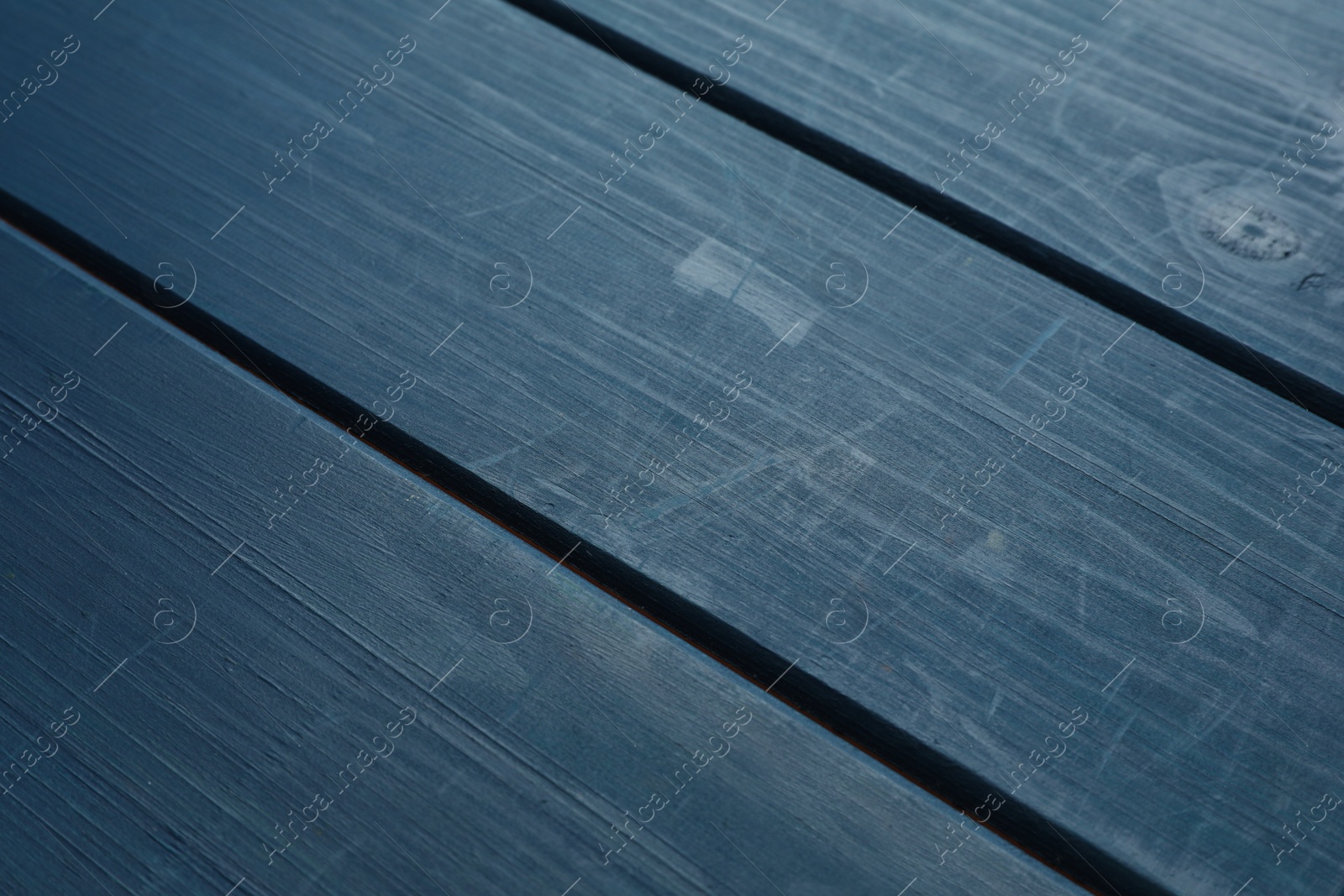 Photo of Old blue wooden surface with scratches as background, closeup