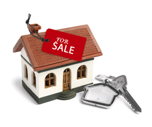 Image of Key and house model with SALE label on white background