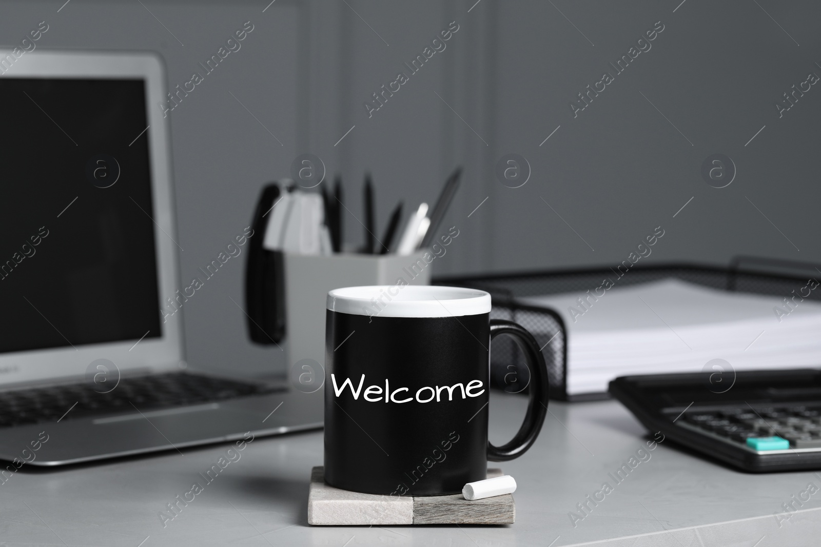 Image of Cup with chalked word Welcome on office desk