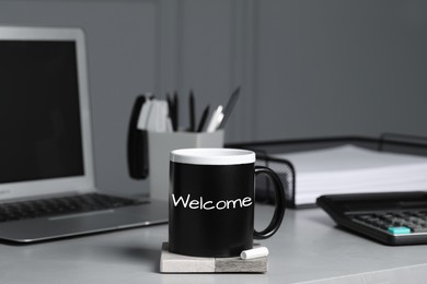 Image of Cup with chalked word Welcome on office desk