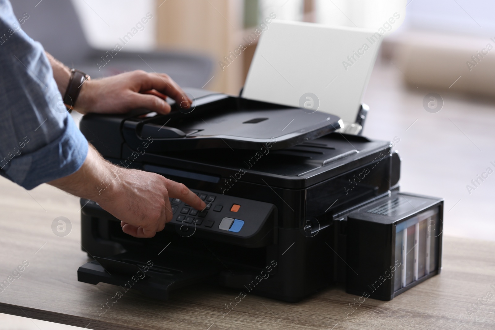 Photo of Employee using modern printer in office, closeup