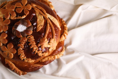 Photo of Korovai on tablecloth, top view. Ukrainian bread and salt welcoming tradition