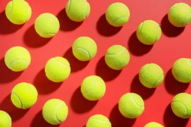 Tennis balls on red background, flat lay. Sports equipment