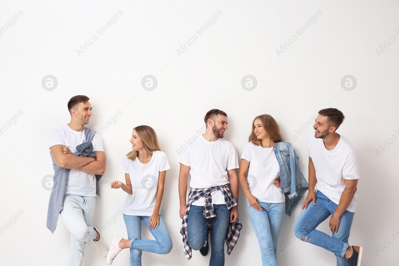 Photo of Group of young people in jeans on light background