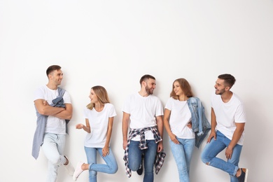 Group of young people in jeans on light background