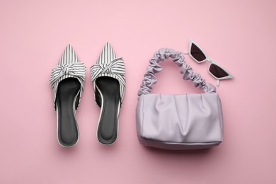 Photo of Stylish woman's bag, shoes and sunglasses on pink background, flat lay