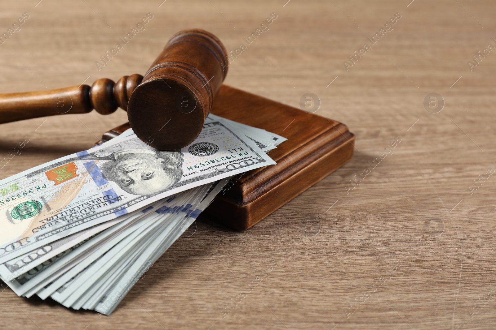 Photo of Judge's gavel and money on wooden table