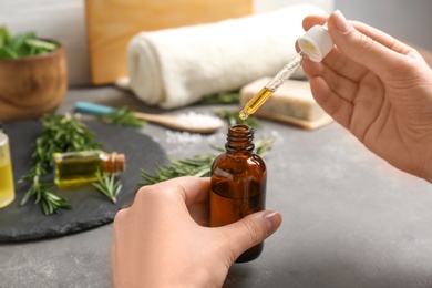 Photo of Woman with bottle of essential oil, closeup