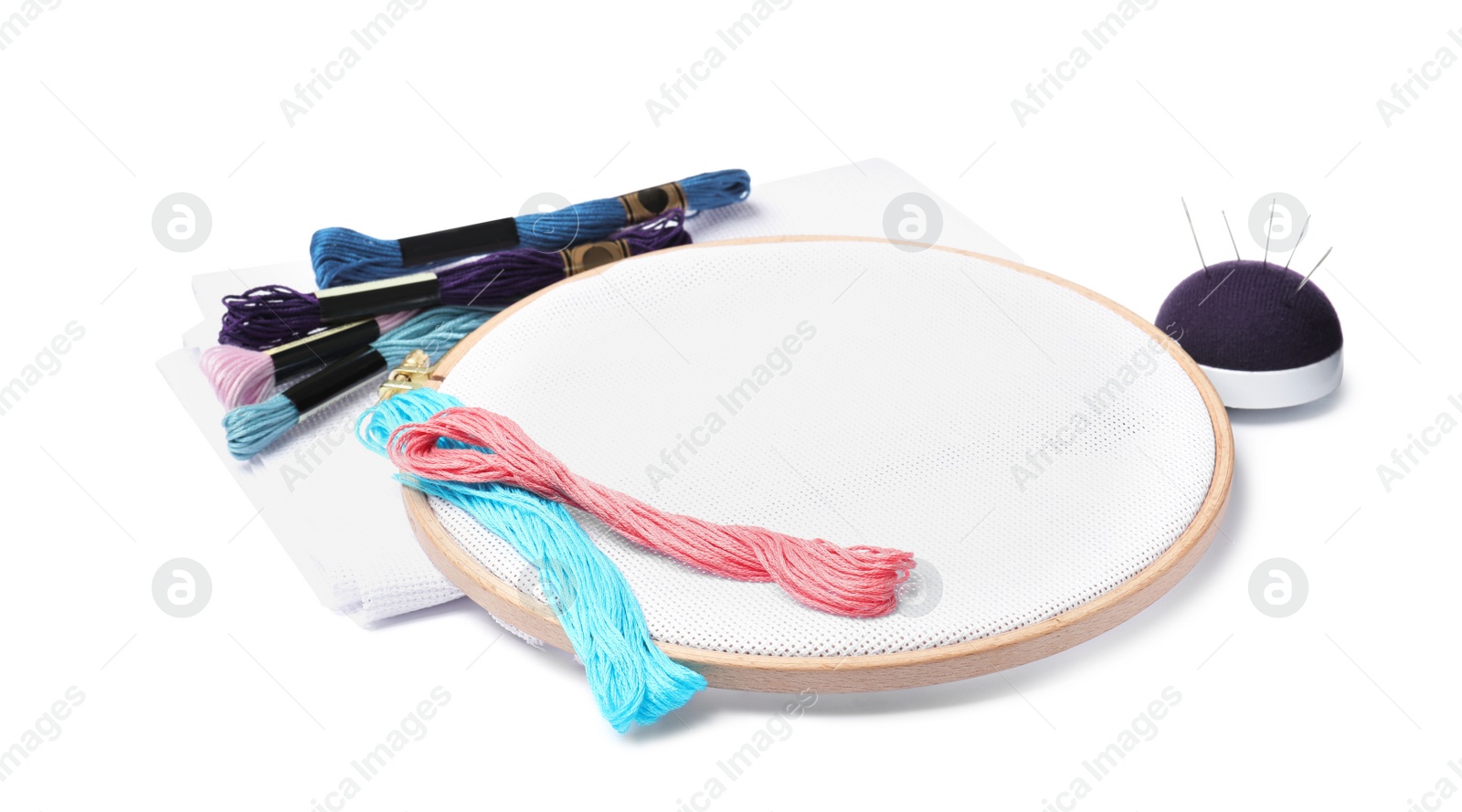 Photo of Colorful threads and different embroidery accessories on white background