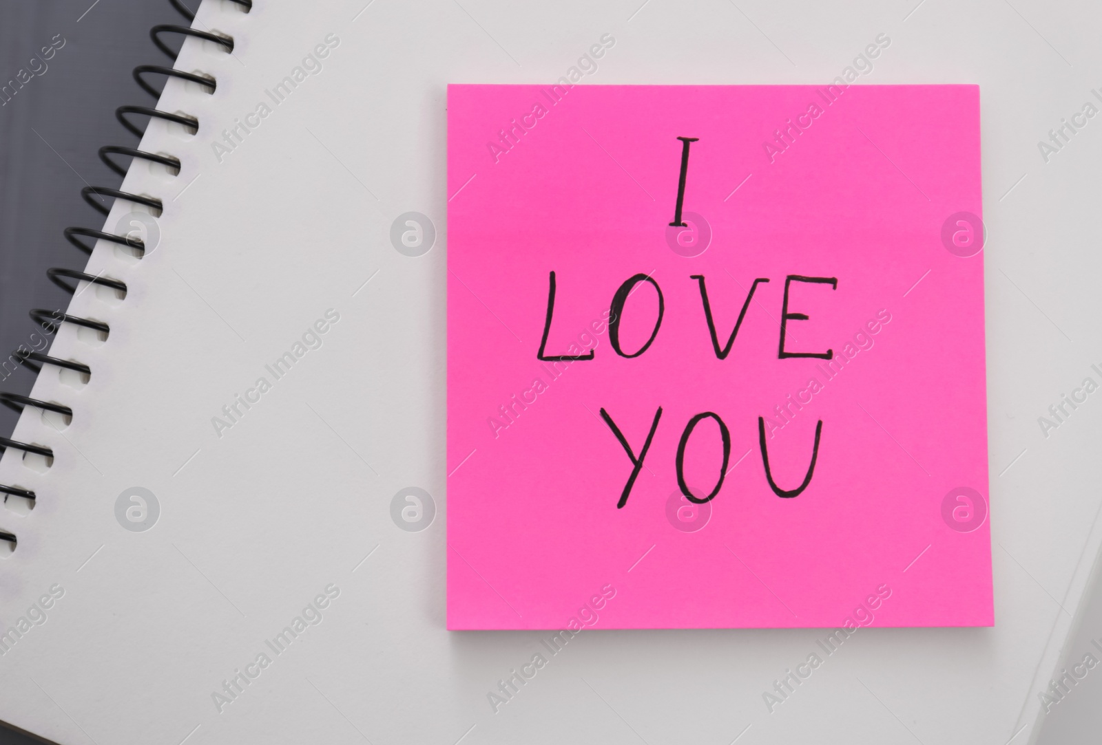 Photo of Memory sticker with phrase I Love You on notebook, top view. Valentine's Day celebration