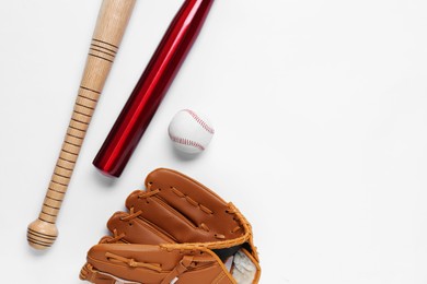 Baseball glove, bats and ball on white background, flat lay. Space for text