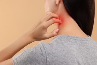 Photo of Suffering from allergy. Young woman scratching her neck on beige background, back view