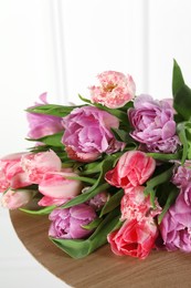 Beautiful bouquet of colorful tulip flowers on wooden table, closeup