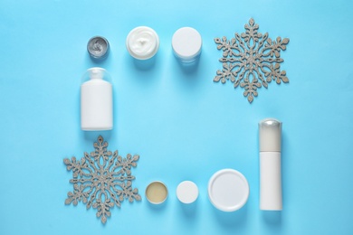 Photo of Set of cosmetic products on blue background, flat lay with space for text. Winter care