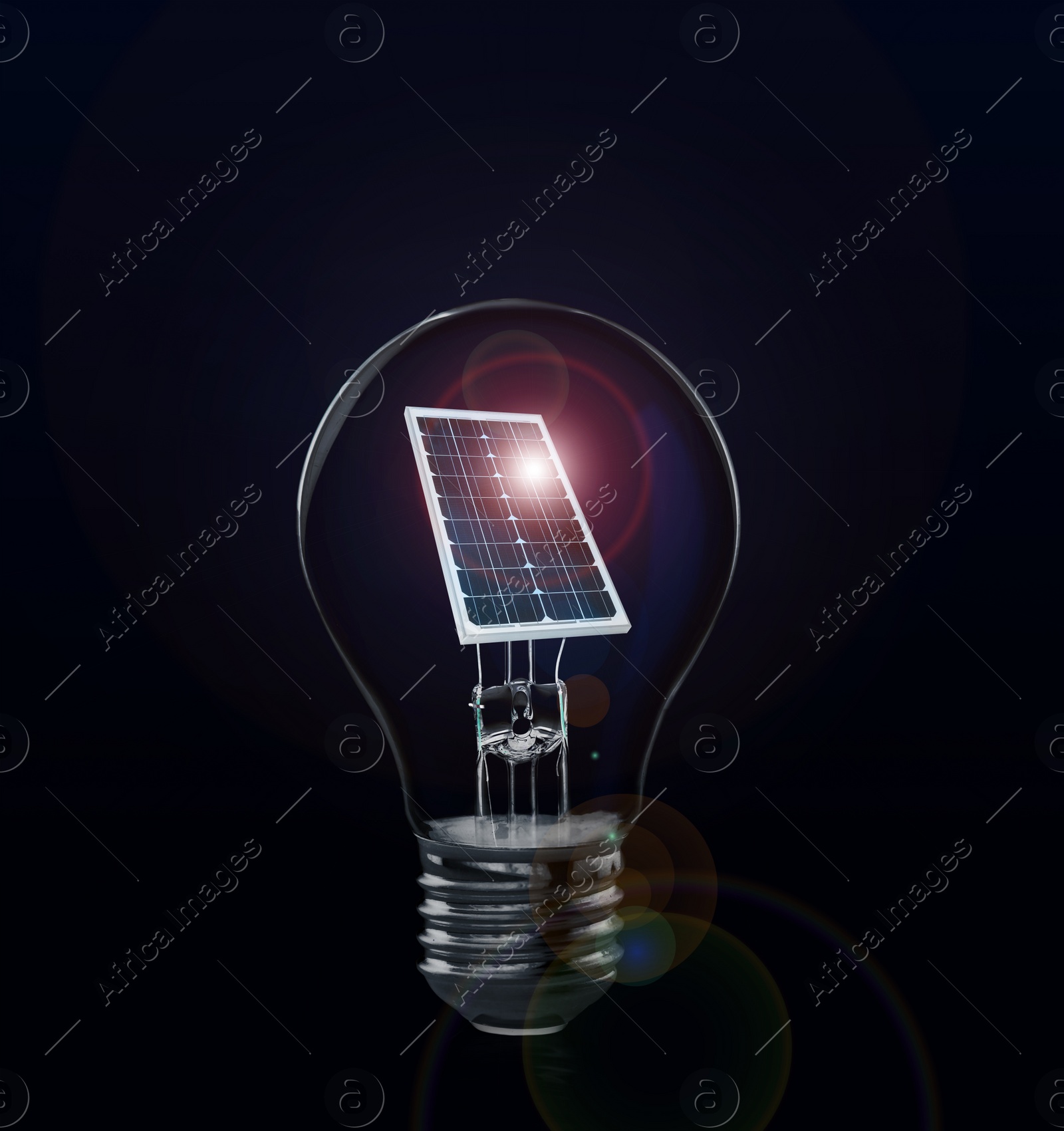 Image of Alternative energy source. Light bulb with solar panel on dark background 