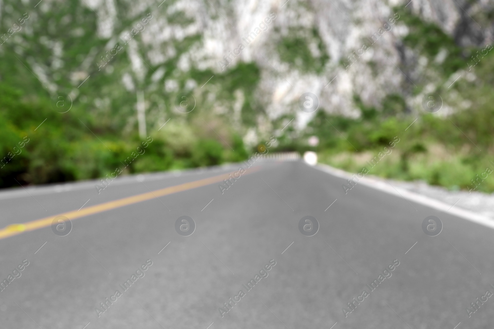 Photo of Mountains and bushes near road, blurred view