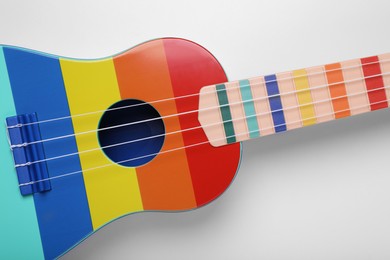 Colorful ukulele on white background, top view. String musical instrument