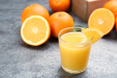 Photo of Delicious orange juice and fresh fruit on grey table. Space for text