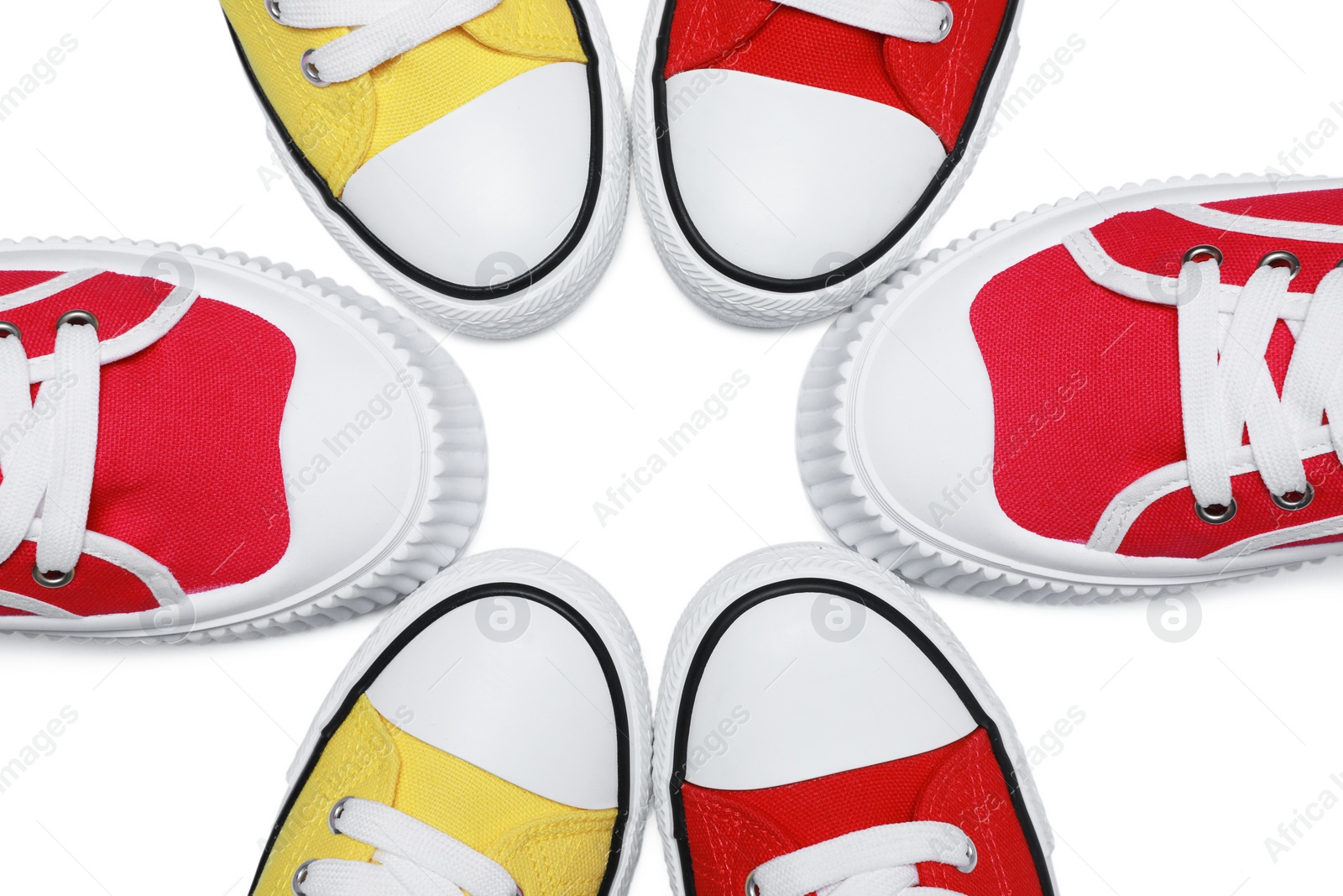 Photo of Yellow and red classic old school sneakers isolated on white, top view