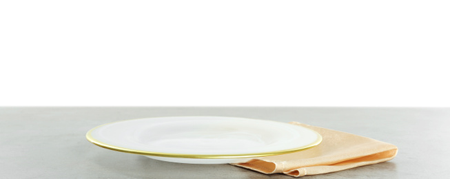 Photo of Empty plate and napkin on grey table