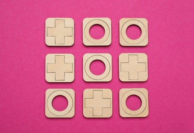 Tic tac toe set on bright pink background, flat lay