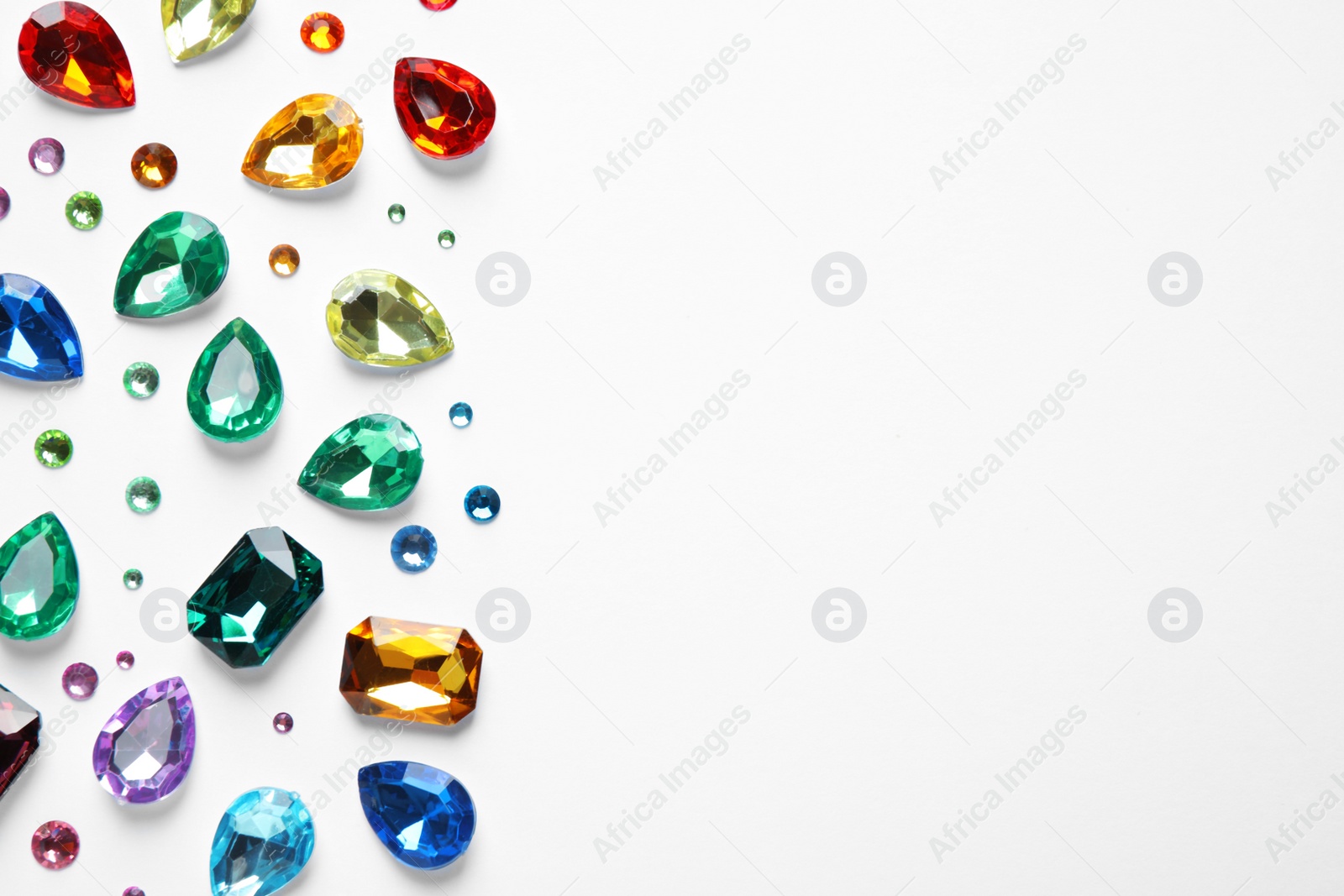 Photo of Different beautiful gemstones on white background, top view