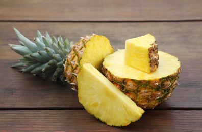 Photo of Delicious cut ripe pineapple on wooden table