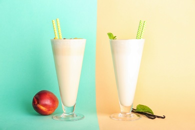 Photo of Glasses with delicious milk shakes on color background