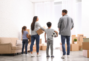 Photo of Family in room with cardboard boxes on moving day