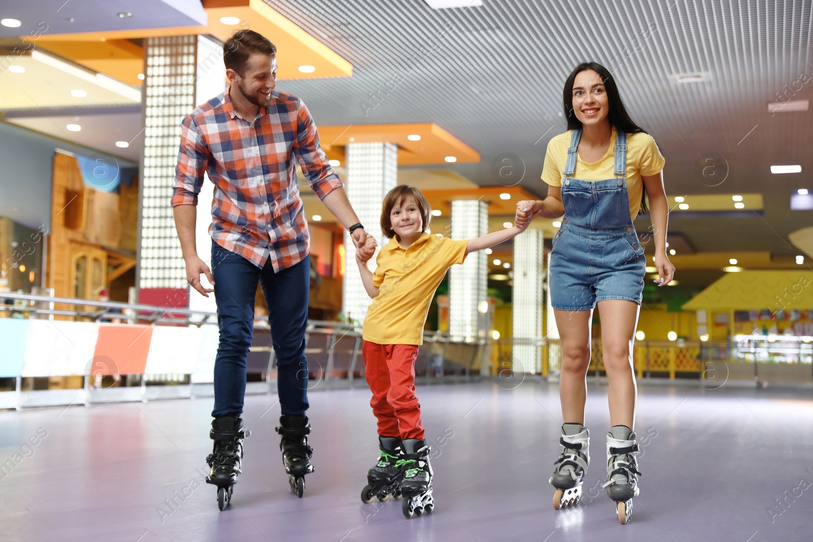 Photo of Happy family spending time at roller skating rink