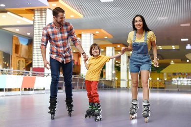 Happy family spending time at roller skating rink