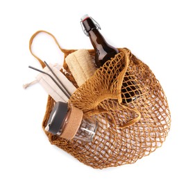 Photo of Fishnet bag with different items isolated on white, top view. Conscious consumption