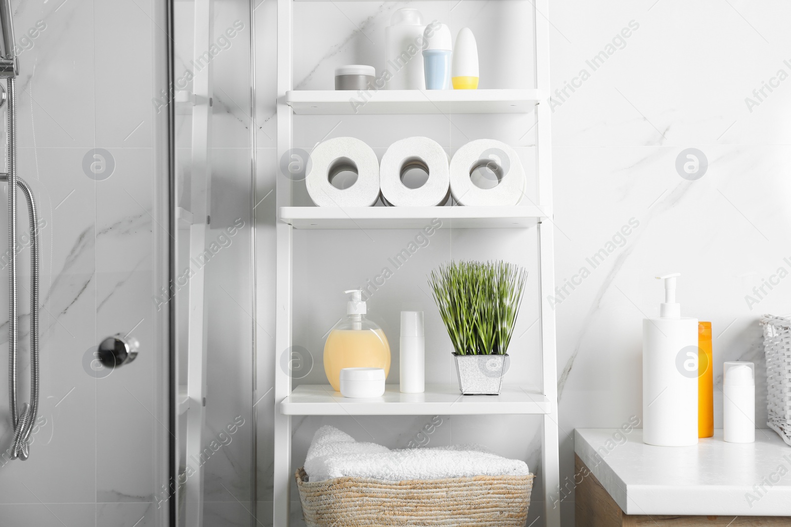 Photo of Toilet paper rolls on shelving unit in bathroom