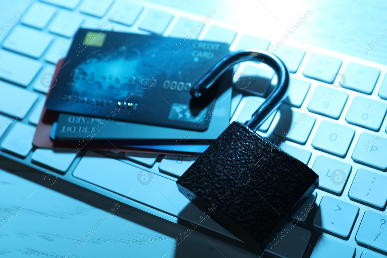 Photo of Credit cards, lock and computer keyboard on table, closeup. Cyber crime