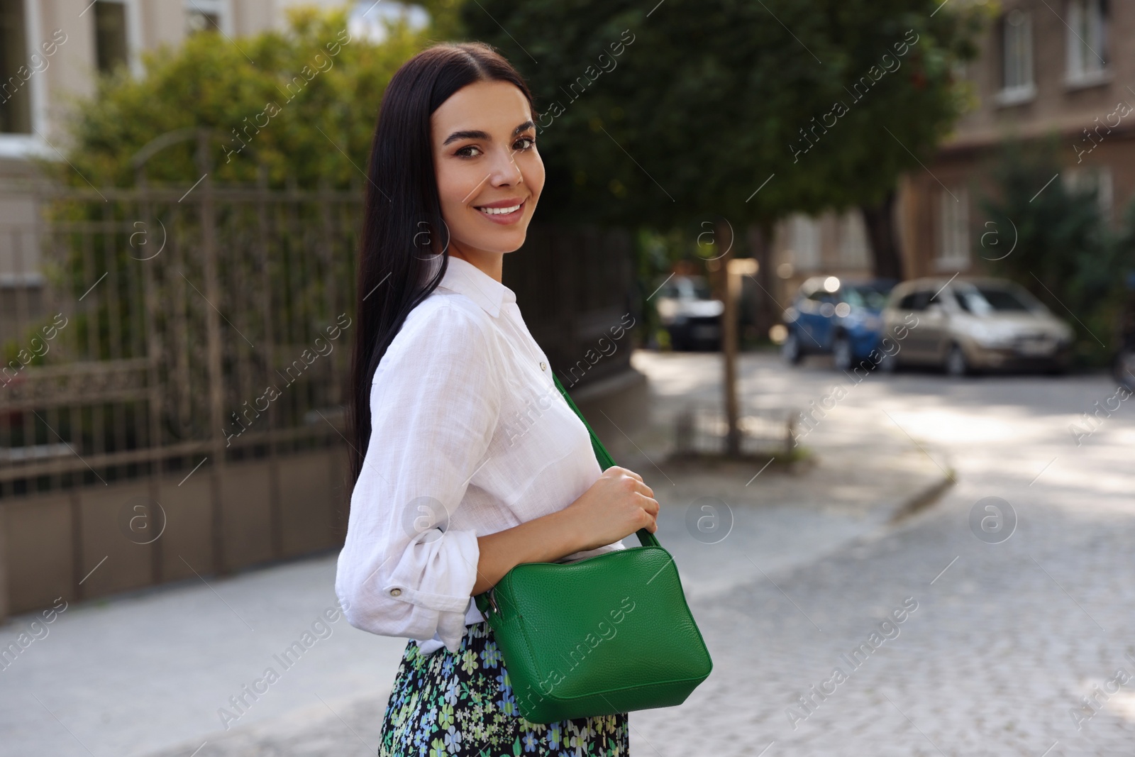 Photo of Beautiful young woman with stylish bag on city street
