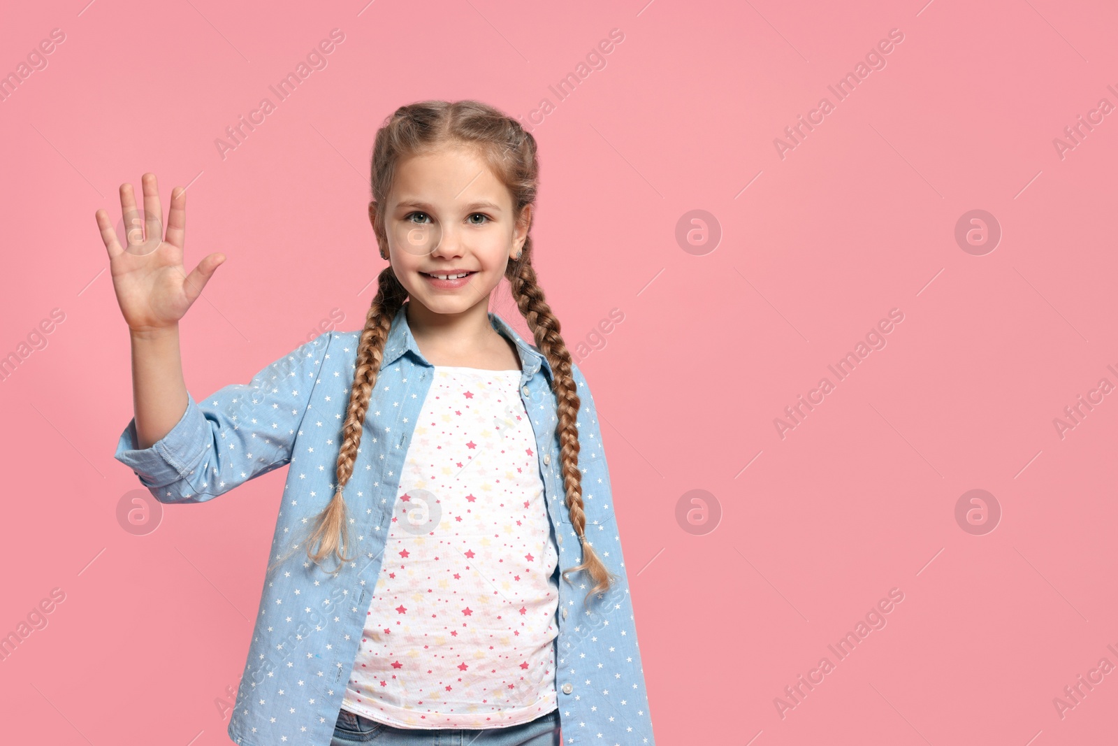 Photo of Cheerful girl giving high five on pink background, space for text