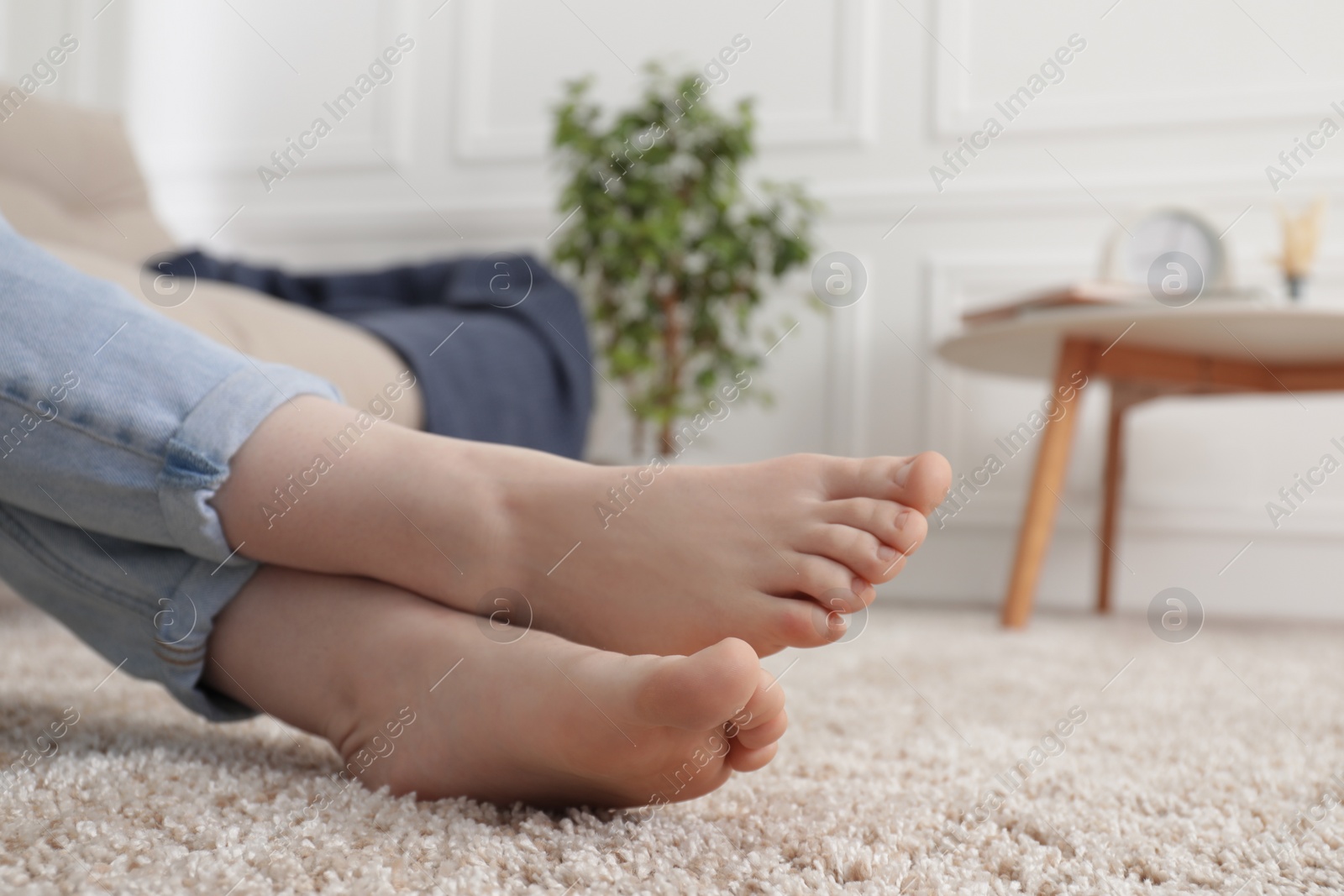 Photo of Woman sitting on soft brown carpet at home, closeup. Space for text