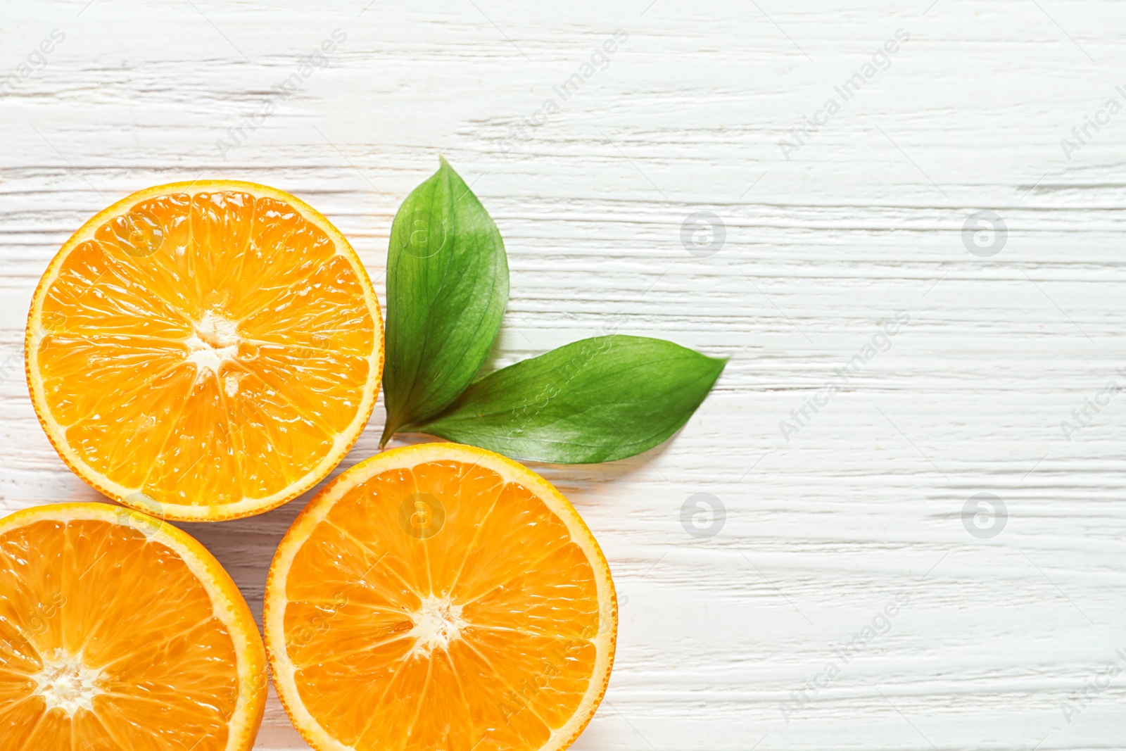 Photo of Fresh oranges with leaves on wooden background, flat lay. Space for text